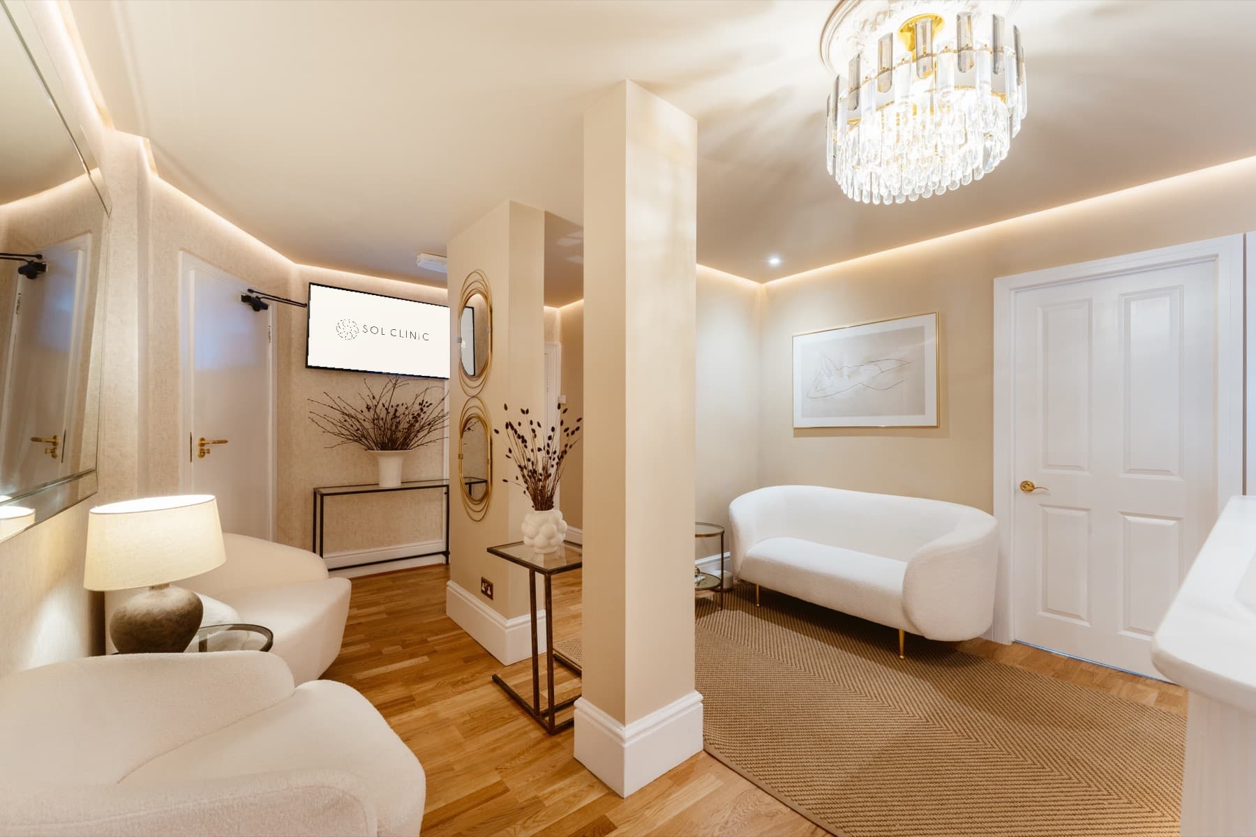 Reception lounge with a crystal chandelier, console table and armchair on oak flooring